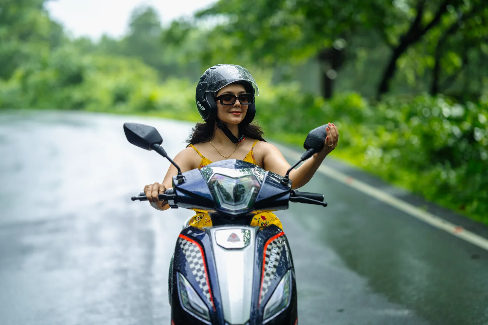 A rider on her Tunwal scooter on a wet monsoon road